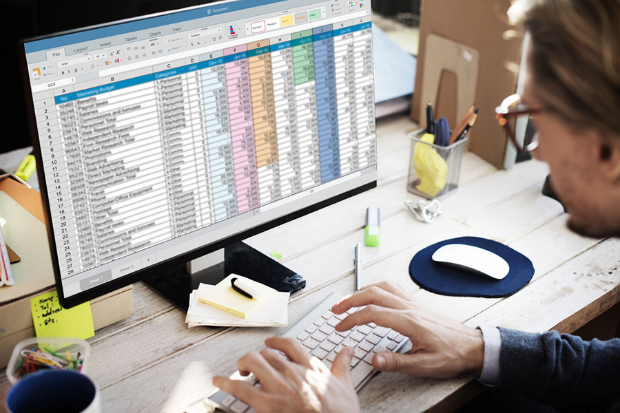 man working on spreadsheets at computer