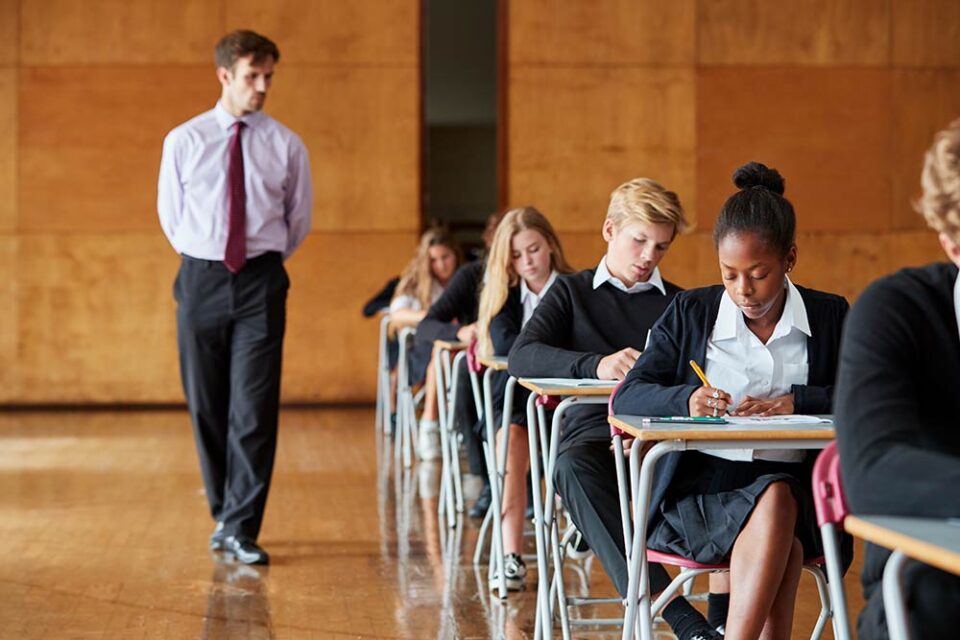 invigilator walking through exam