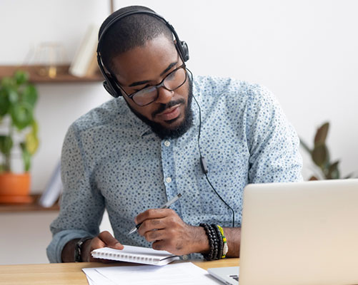 man wearing headphones working on computer